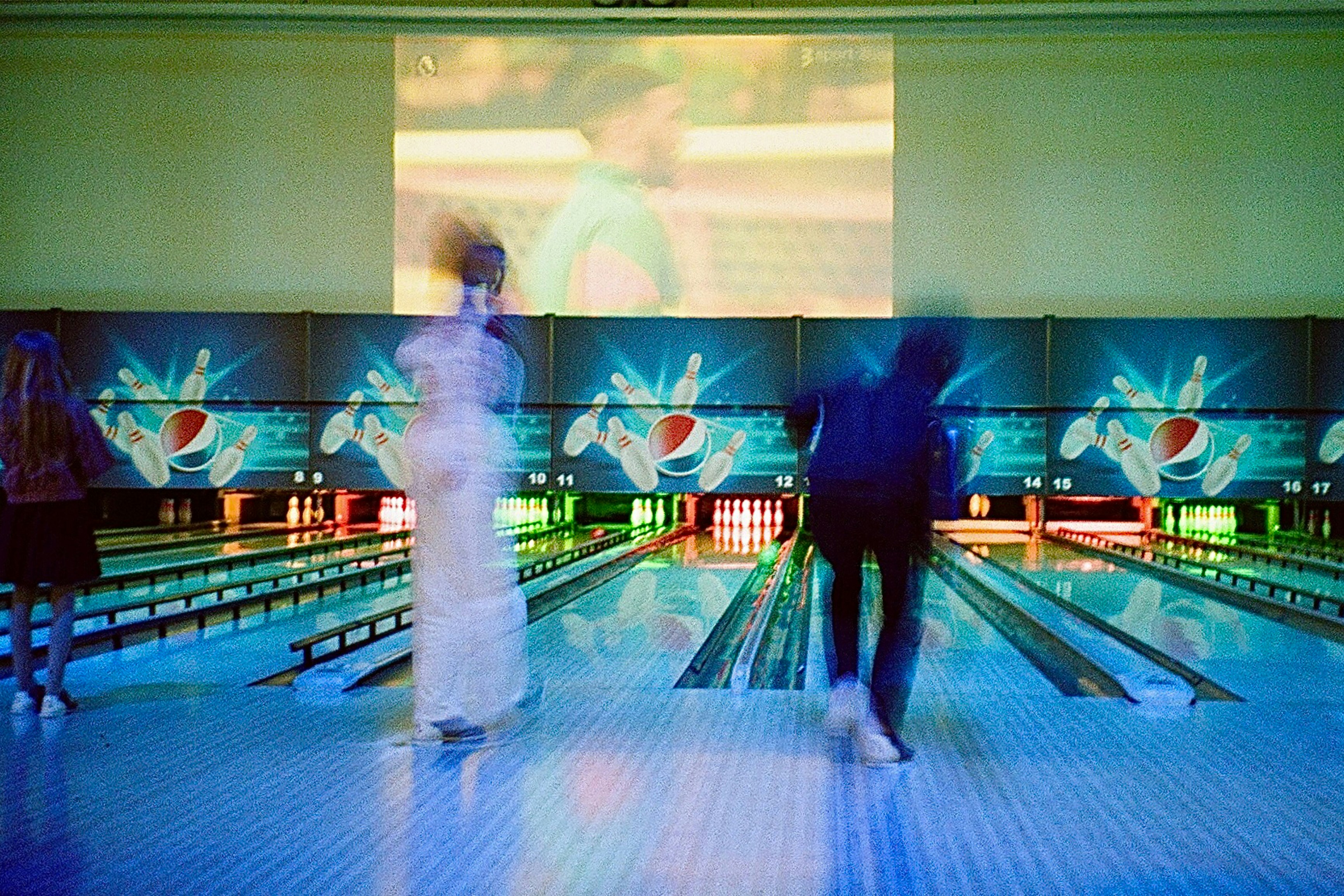 Cosmic bowling lanes with teal and green lighting